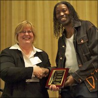 Student shaking hands and receiving a plaque