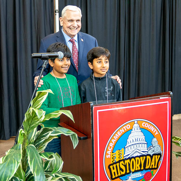 Students posing behind lectern