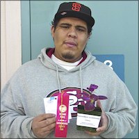 Student holding plant and award ribbon