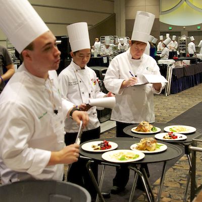 Judges critique student dishes.