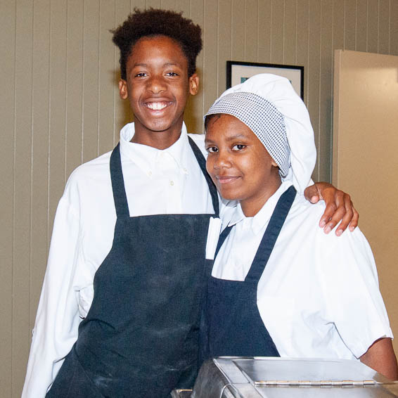 Students posing in front of food warmer