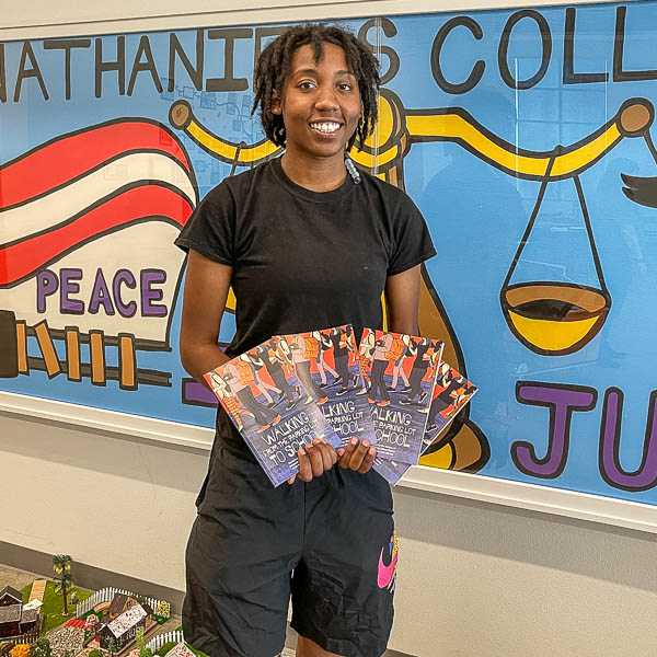 Student holding copies of the book.