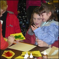 Adults helping student with craft project