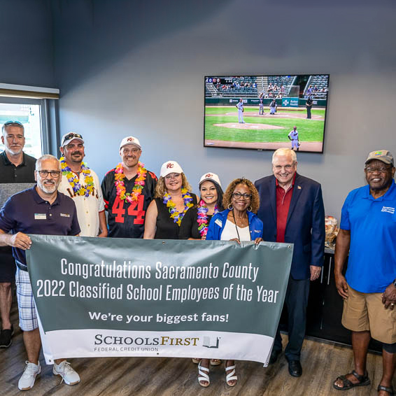 Group posing with SchoolsFirst congratulations sign