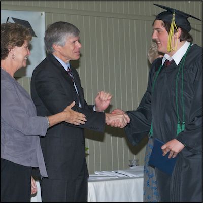Graduate receiving diploma and shaking hands