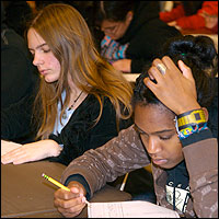 Students holding pencils during a practice exam