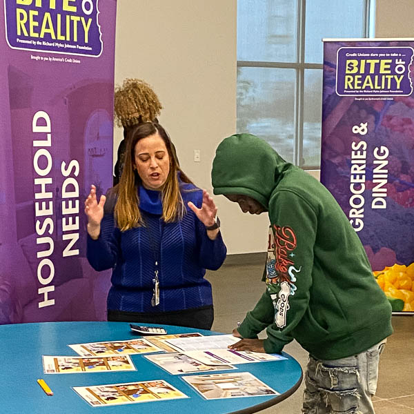 Volunteer helping student at housing needs station