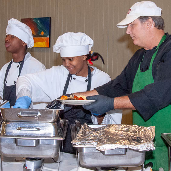 Teacher helping students plate food