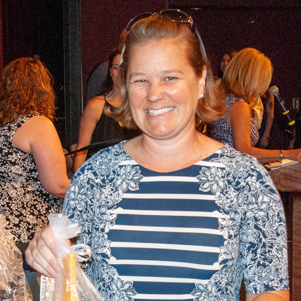 Smiling Leadership Institute graduate holding gift bag