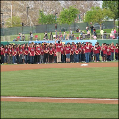 Teacher directing band students on-field