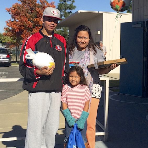 Student with family holding turkey and pie