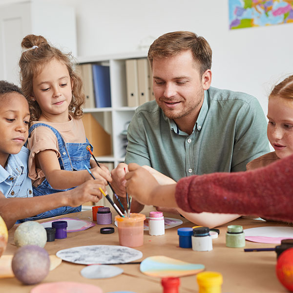 Teacher helping students paint