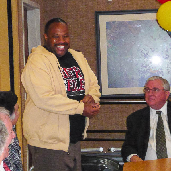 Daniel Watts stands during staff meeting