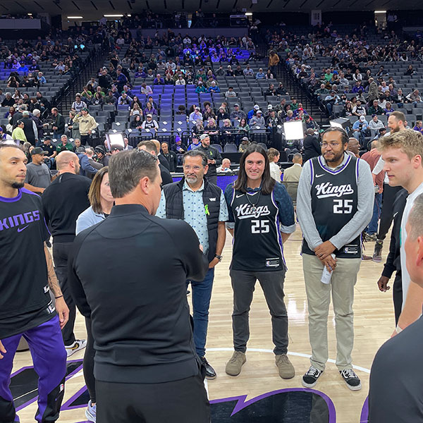 Marc Vankeuren and Joshua Weeks on court with coaches and players