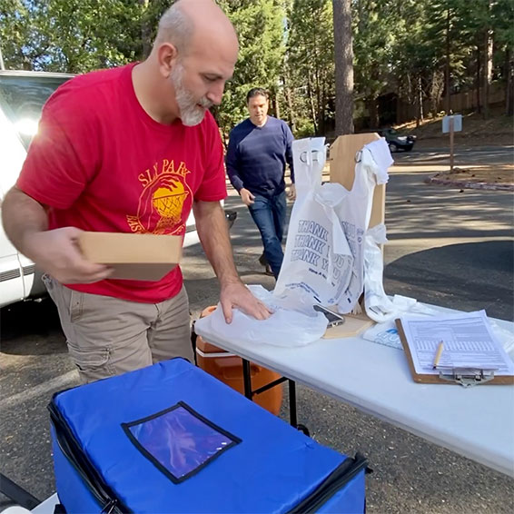 Staff bagging individual meals in parking lot