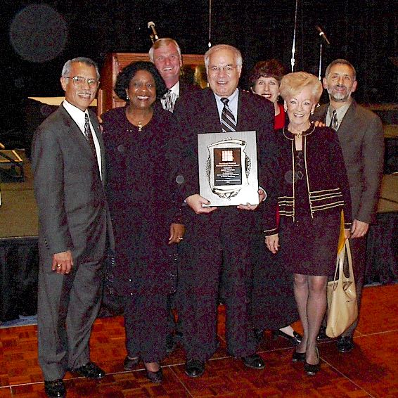 Dr. David P. Meaney, with colleagues, holding plaque.