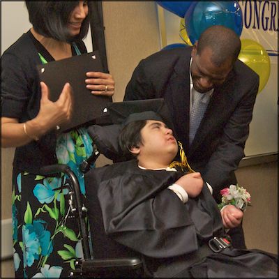 Student in wheelchair receiving certificate