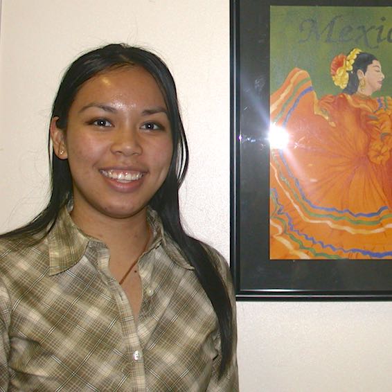Student artist posing with Mexico artwork
