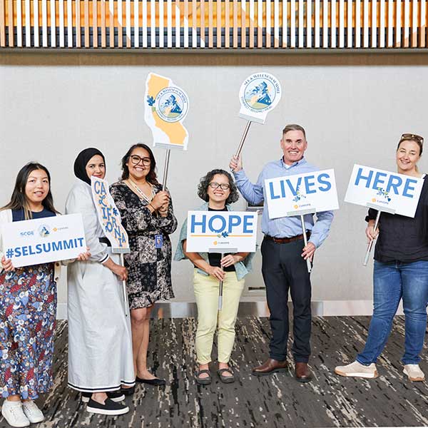 Staff posing with 'Hope Lives Here' signs