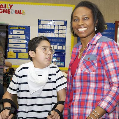 Oluchi Okemiri smiling, standing next to a student