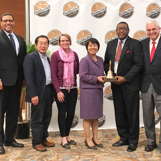 Dignitaries posing with bell award