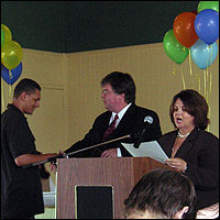 Student receiving award from Michael Laharty and Debi Lauer