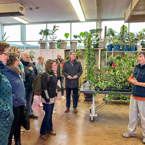 Visitors standing near tables full of plants