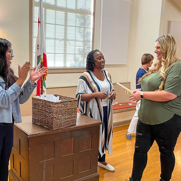 Staff clapping for client receiving a certificate