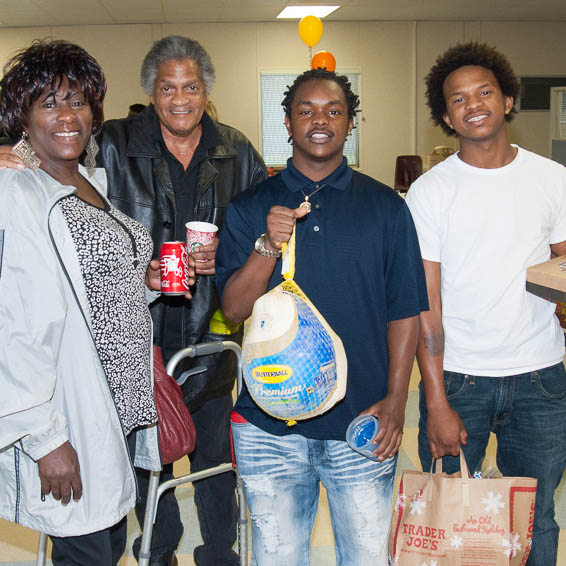 Family happily holding frozen turkey and other groceries