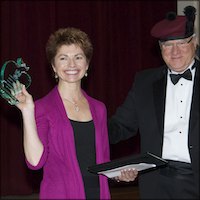 JoEllen Shanks holding up glass plaque