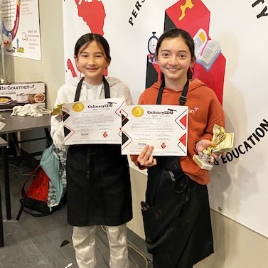 Students posing with trophies and certificates