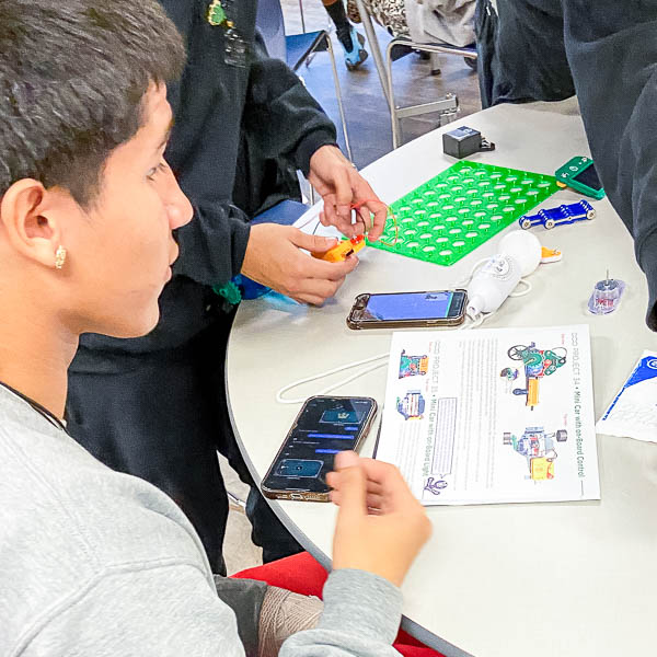 Student working on a mini-car project with on-board control