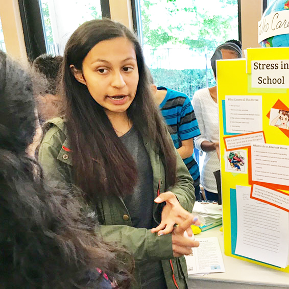 Student standing in front of 'Stress in School' display board