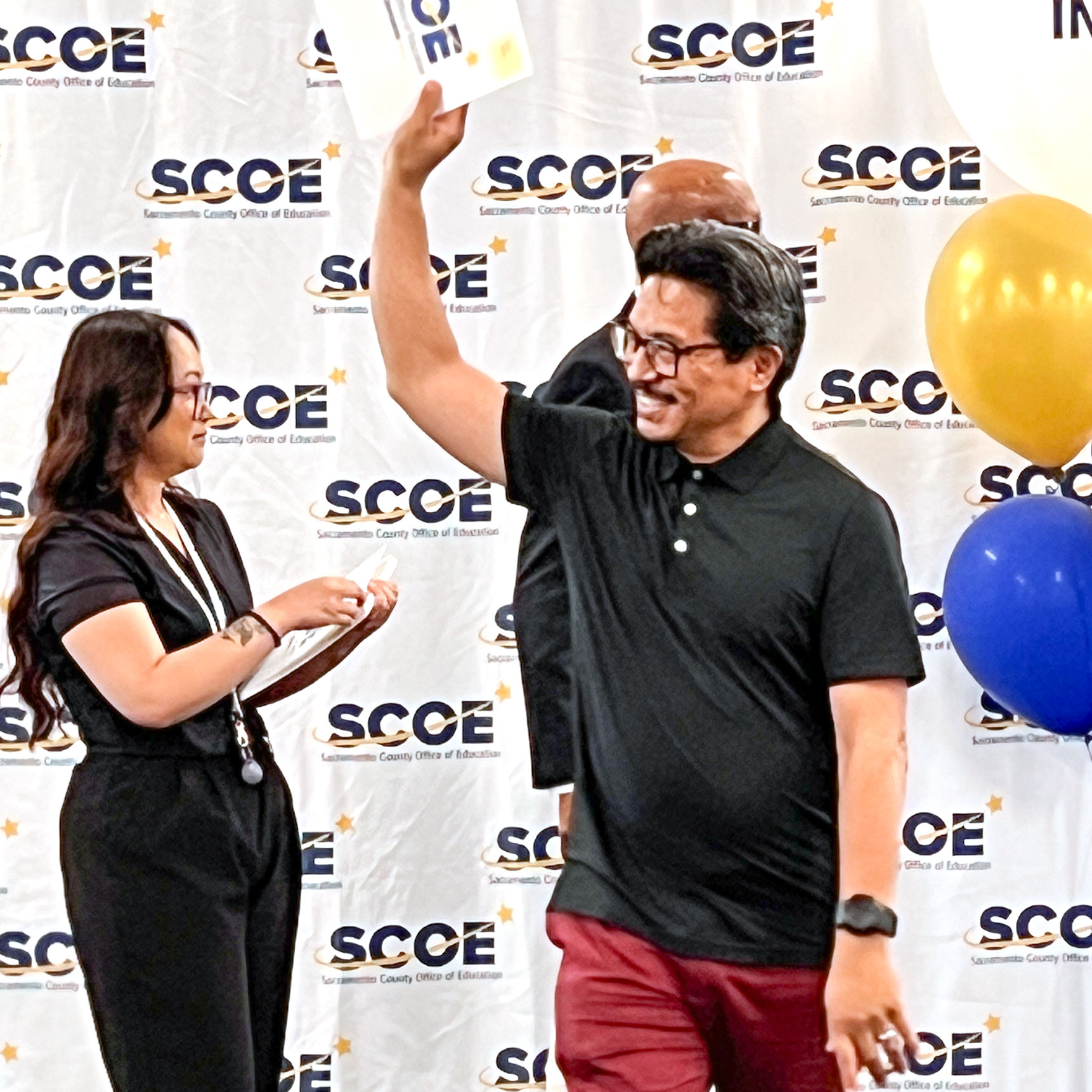 Credential recipient triumphantly holding up his certificate