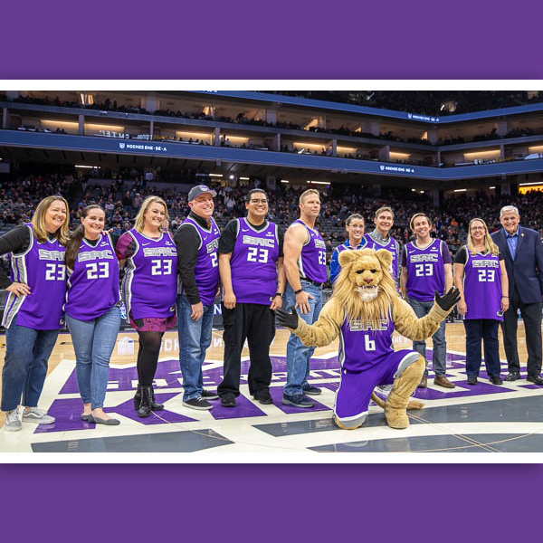 Teachers of the Year posing on-court with mascot