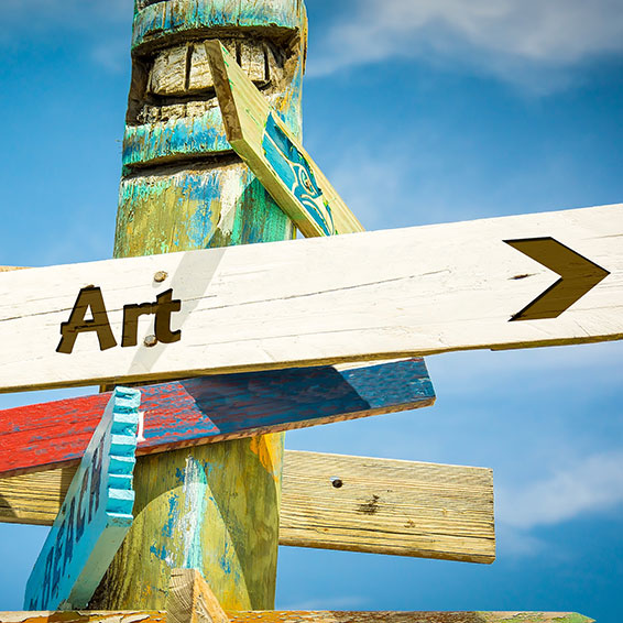 Totem pole sign pointing to art and beach
