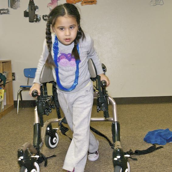 Young girl using assistive device to walk