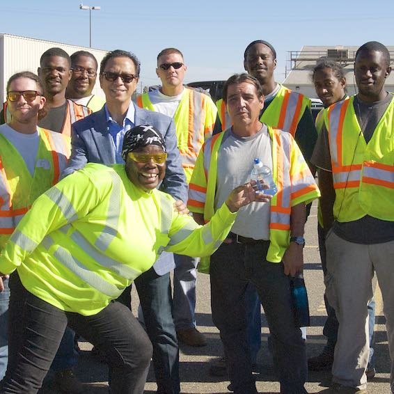 Group of attendees in yellow safety vests posing