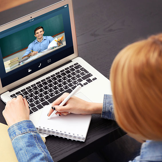 Student video conferencing with teacher using laptop