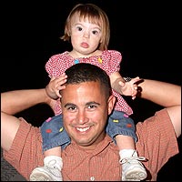 Smiling father with daughter riding on his shoulders