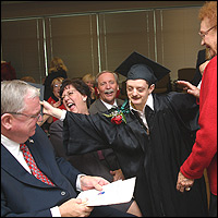 Graduate hugging superintendent and Board member