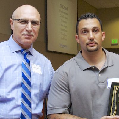 Client receiving plaque commemorating completion of DRC program