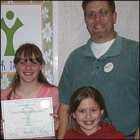 Student standing with family and holding award
