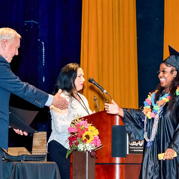 Dave Gordon shaking hands with a graduate