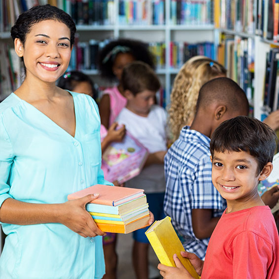 Librarian giving stack of books to student