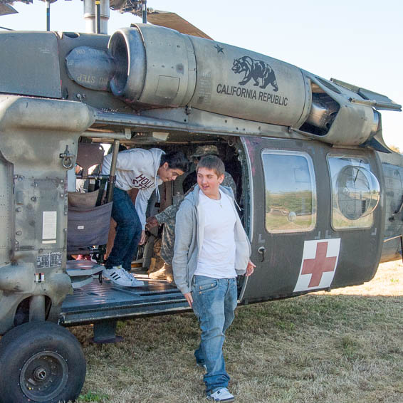 Students climbing out of helicopter door after tour