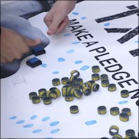 Students stamping fingerprints to mark their pledge