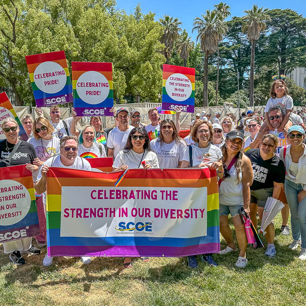 SCOE staff posing at the capitol with signs and banner: celebrating the strength in our diversity