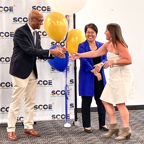 Steven Winlock and Nancy Herota shaking hands with graduates of the program