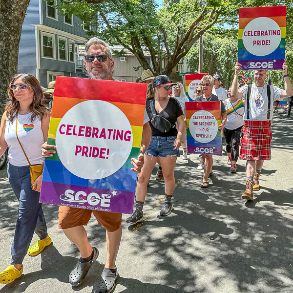 SCOE staff holding signs while marching in the parade